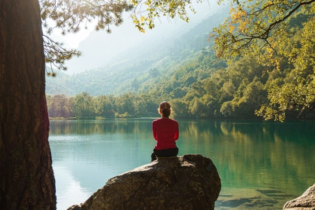 A woman sitting on a log reflecting on her day. Nice morning routine